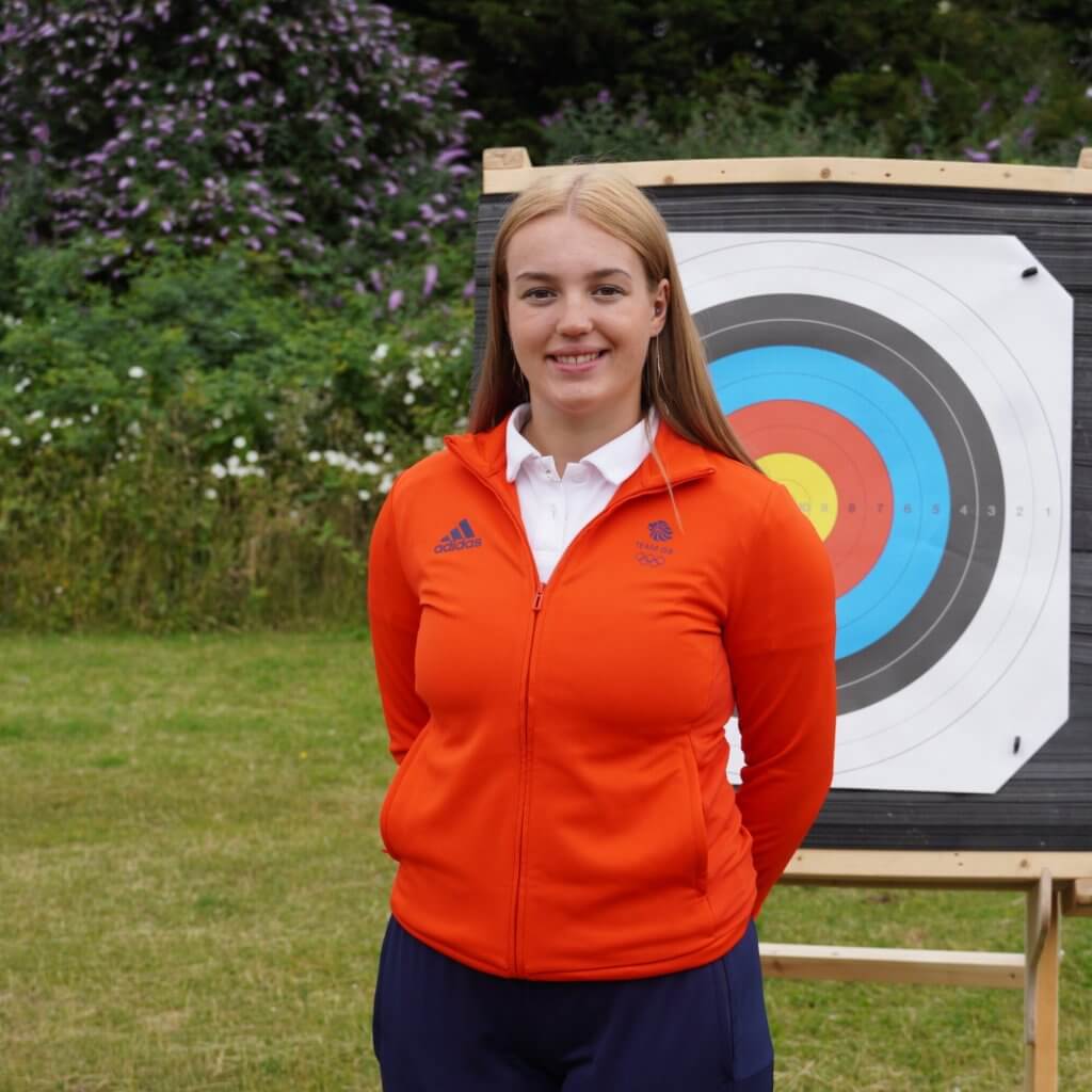 Megan Havers in front of archery target